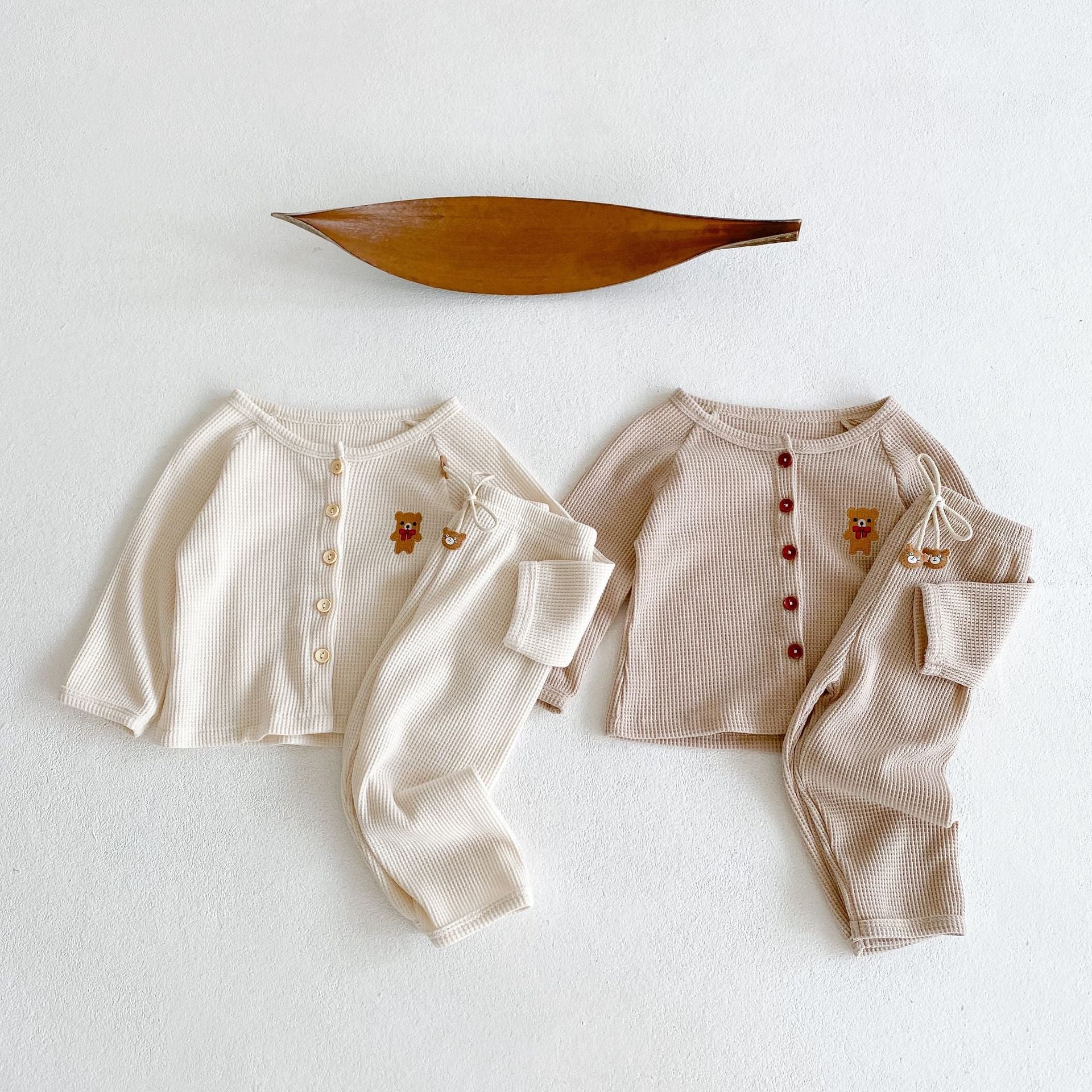 Baby outfit featuring a cartoon bear embroidery, waffle knitted cardigan, and combo pants in khaki and apricot colors.