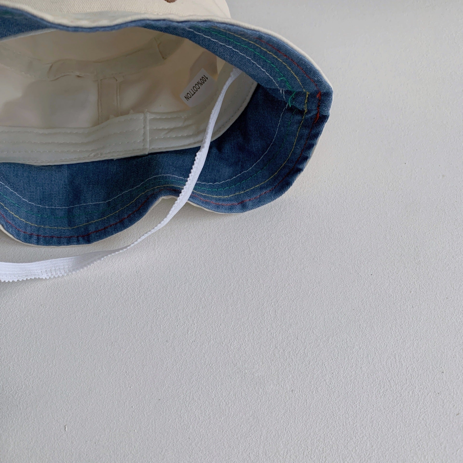 Baby wearing a cartoon embroidered sunshade bucket hat in blue, enjoying outdoor playtime.