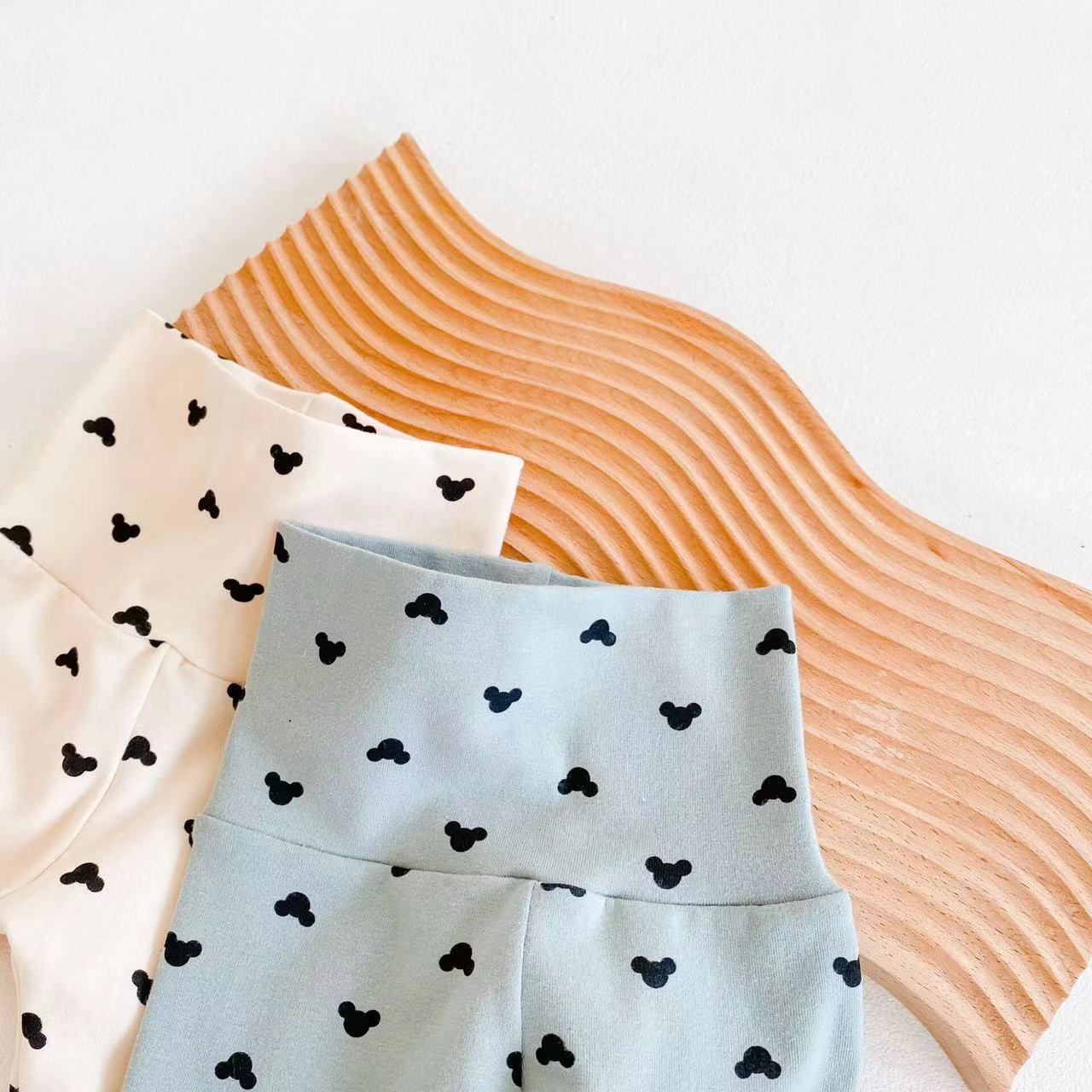 A soft cotton baby onesie and trousers set featuring a colorful cartoon print, available in blue and beige, perfect for baby boys and girls.