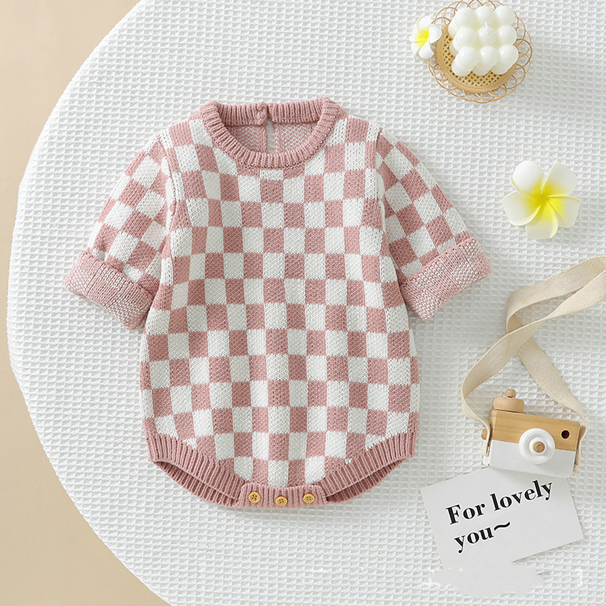 A stylish Baby Checkerboard Pattern Quality Knit Onesie in black, pink, and blue, showcasing its soft cotton fabric and trendy plaid design.