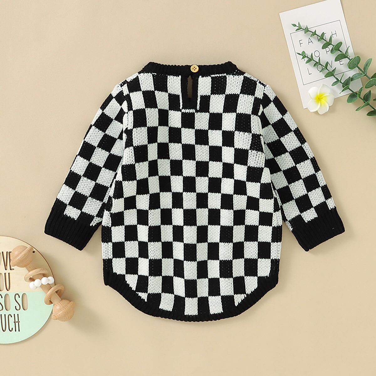 A stylish Baby Checkerboard Pattern Quality Knit Onesie in black, pink, and blue, showcasing its soft cotton fabric and trendy plaid design.