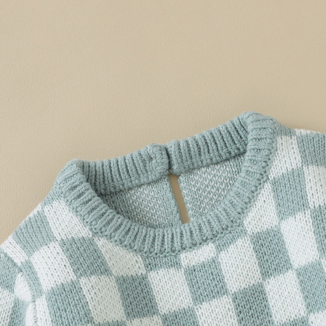 A stylish Baby Checkerboard Pattern Quality Knit Onesie in black, pink, and blue, showcasing its soft cotton fabric and trendy plaid design.