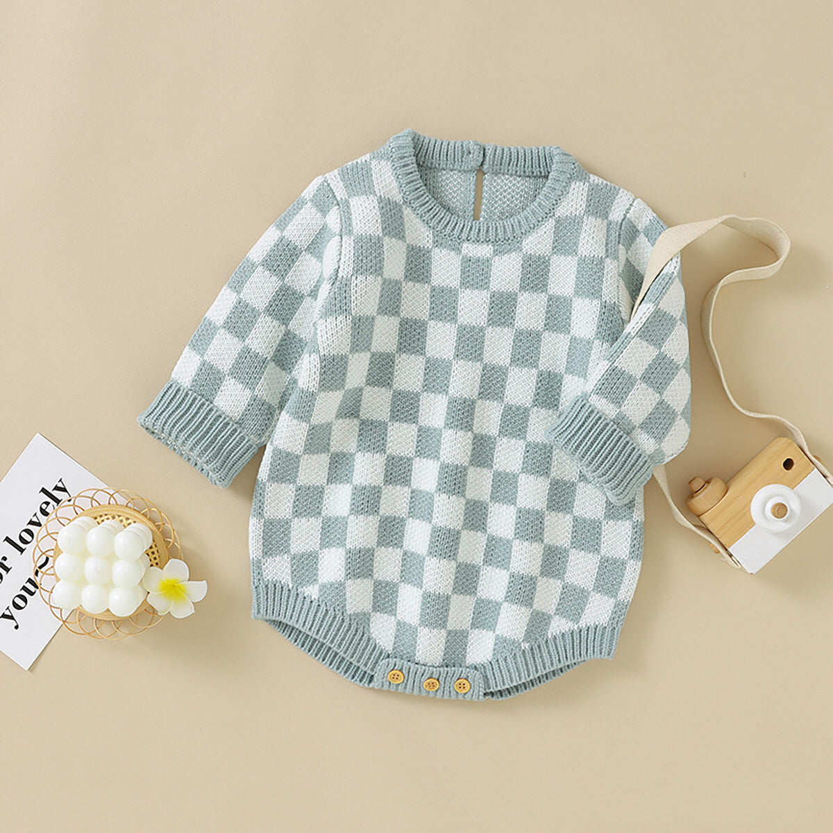A stylish Baby Checkerboard Pattern Quality Knit Onesie in black, pink, and blue, showcasing its soft cotton fabric and trendy plaid design.