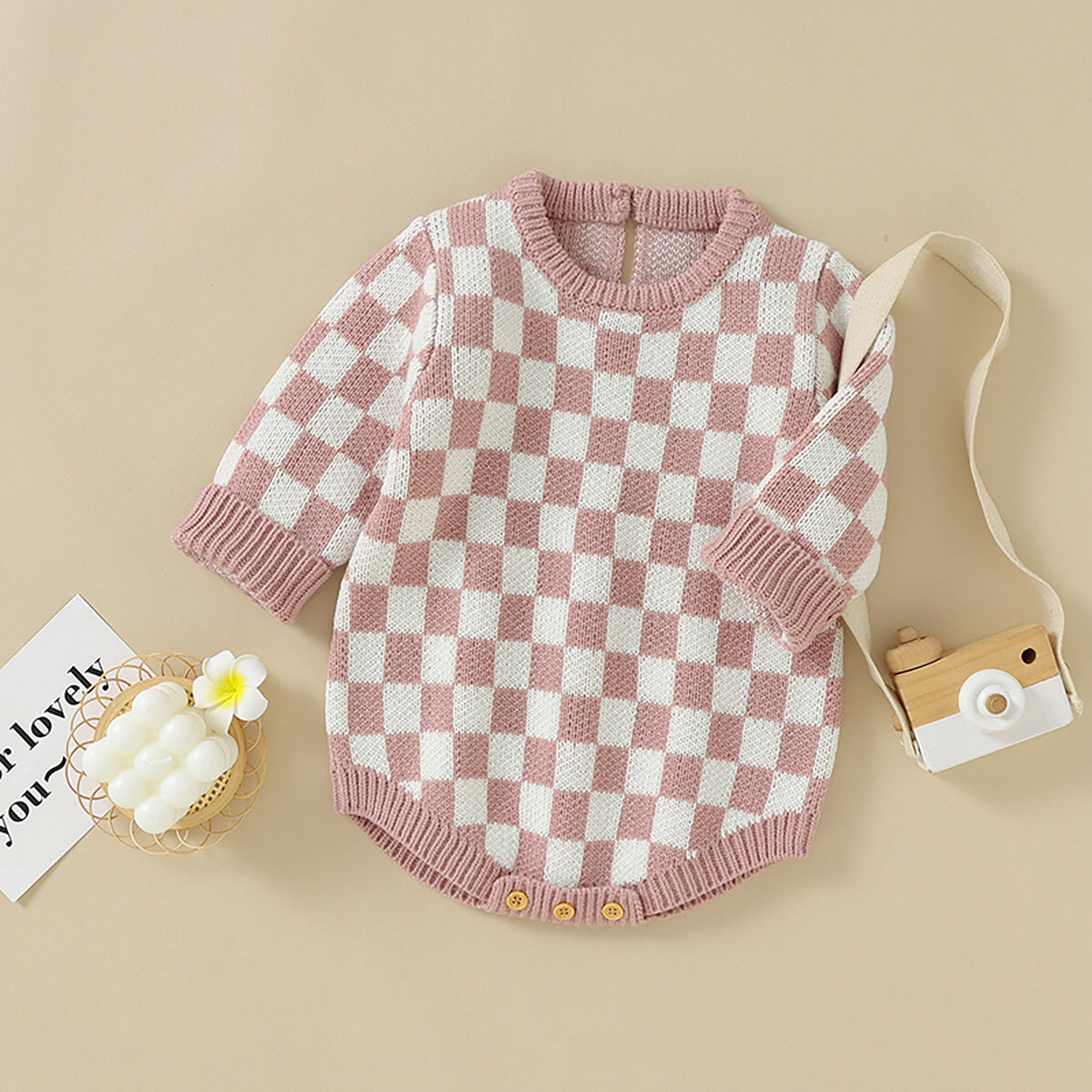 A stylish Baby Checkerboard Pattern Quality Knit Onesie in black, pink, and blue, showcasing its soft cotton fabric and trendy plaid design.