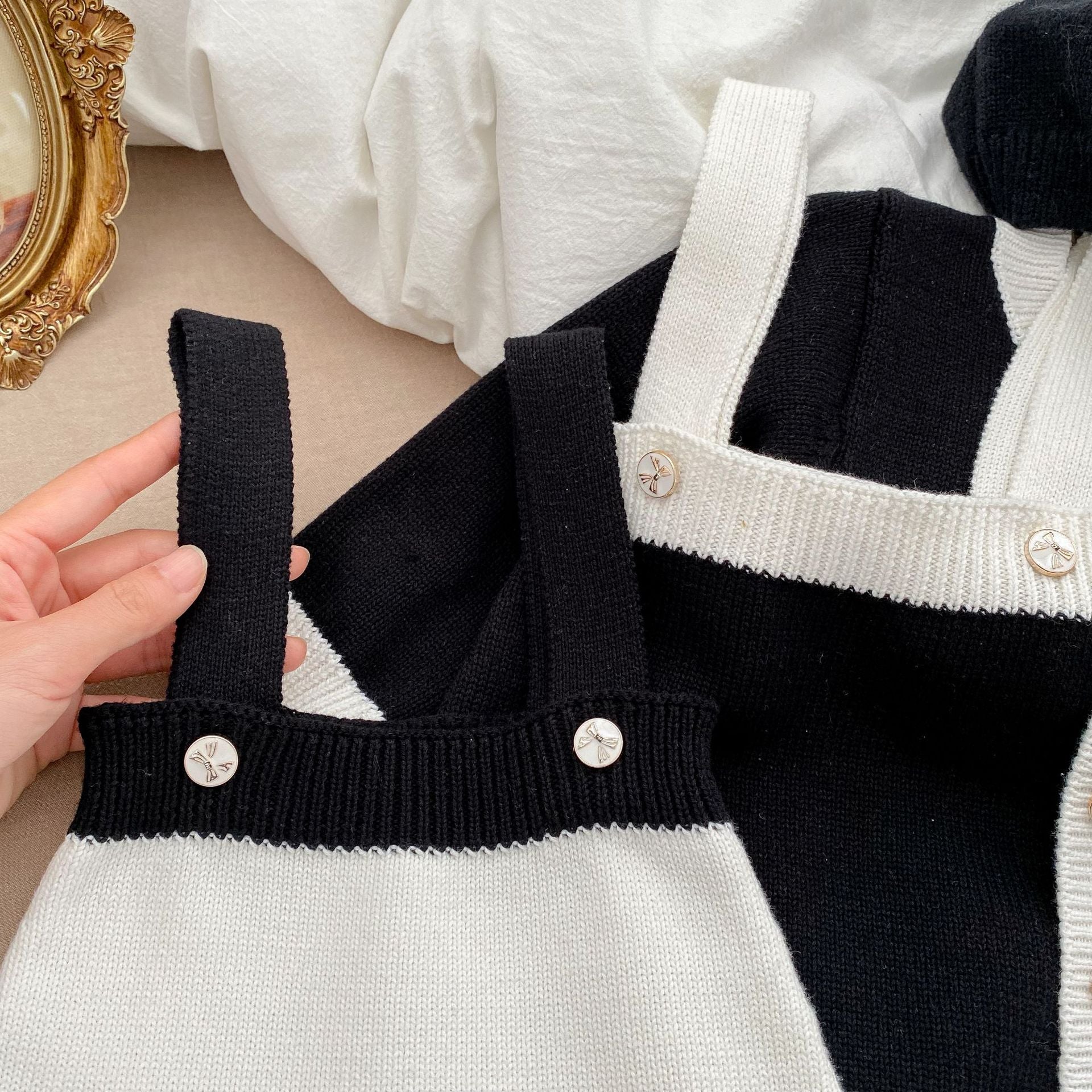 Baby girl wearing a stylish sleeveless onesie with a matching cardigan, showcasing a color matching design in soft cotton fabric.