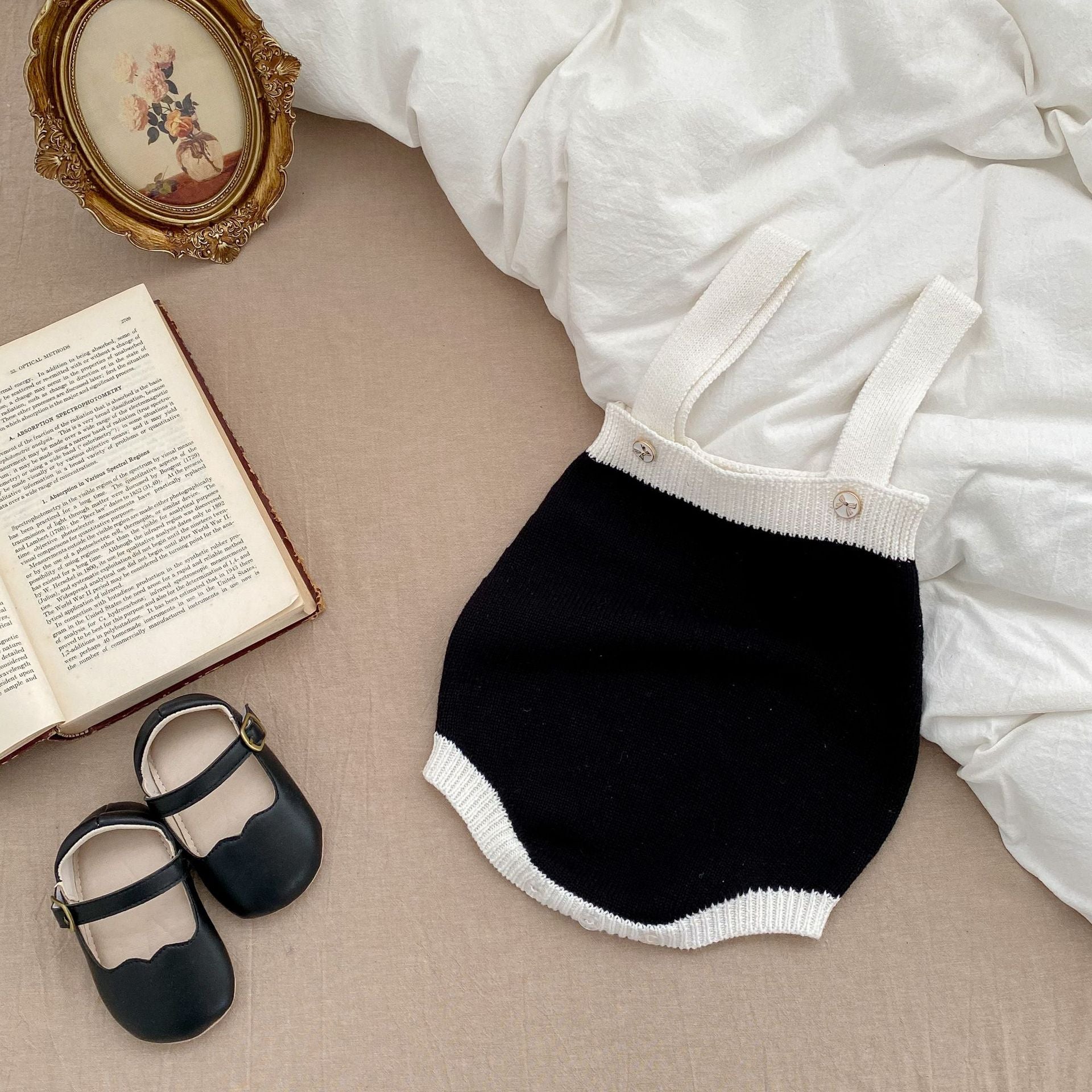 Baby girl wearing a stylish sleeveless onesie with a matching cardigan, showcasing a color matching design in soft cotton fabric.