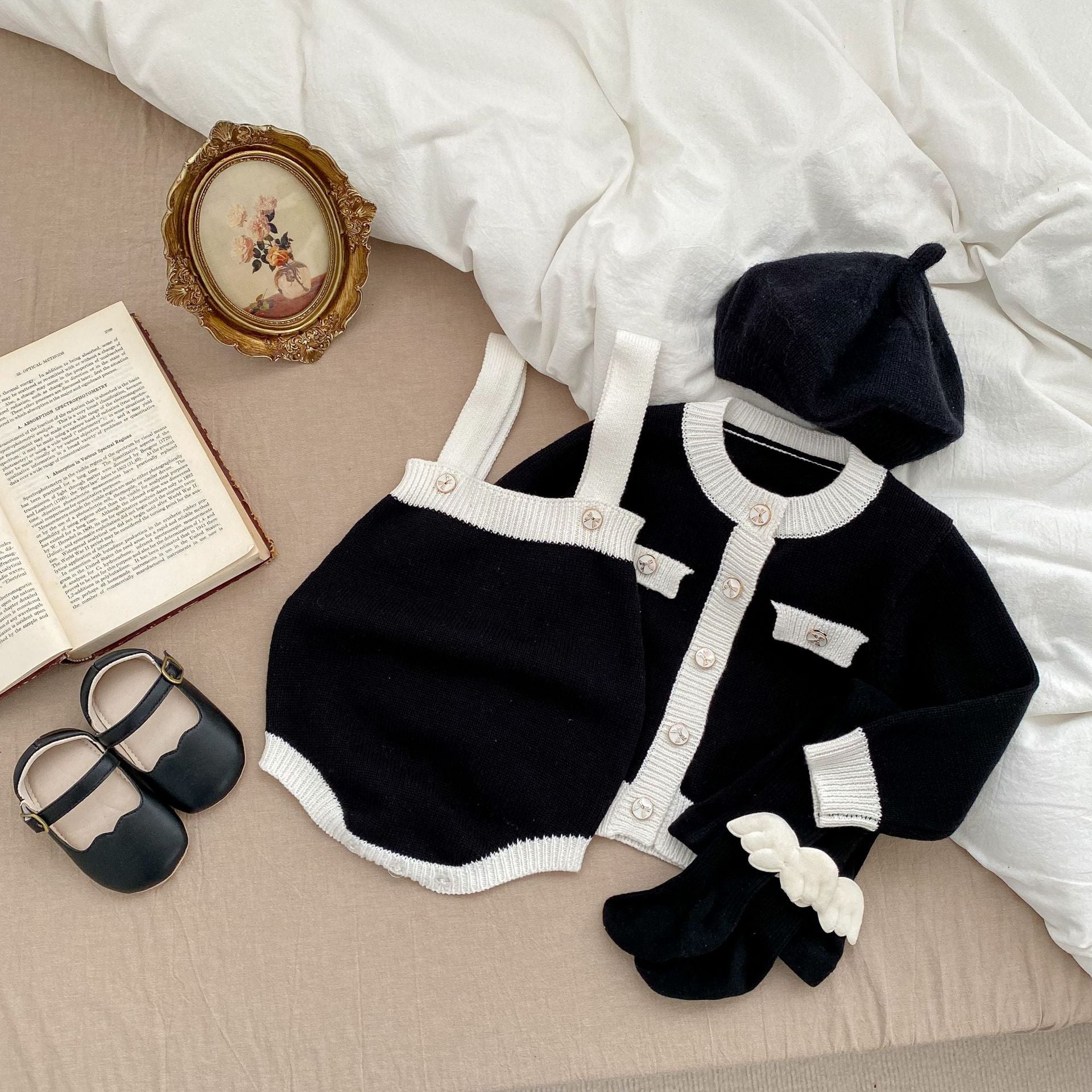 Baby girl wearing a stylish sleeveless onesie with a matching cardigan, showcasing a color matching design in soft cotton fabric.