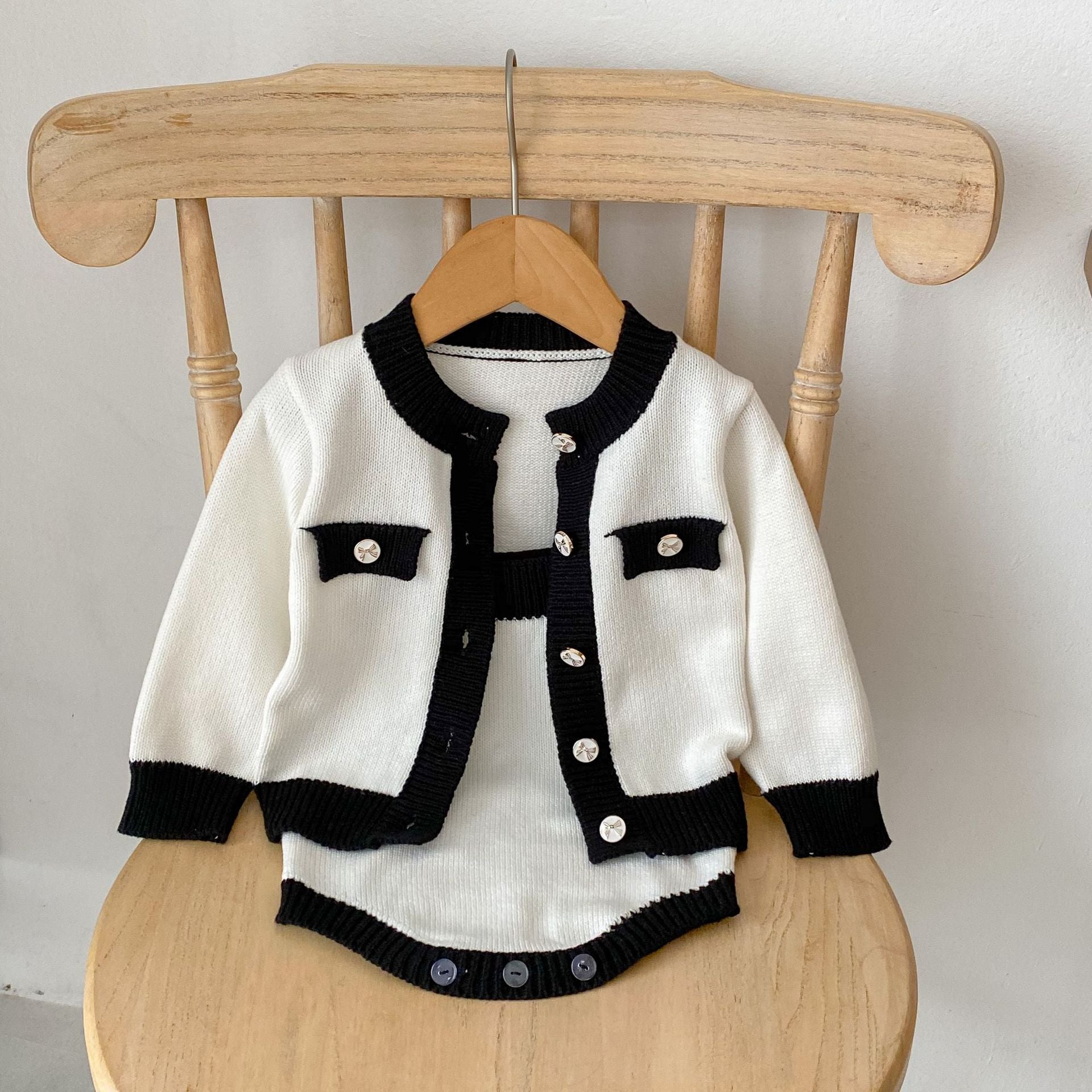 Baby girl wearing a stylish sleeveless onesie with a matching cardigan, showcasing a color matching design in soft cotton fabric.
