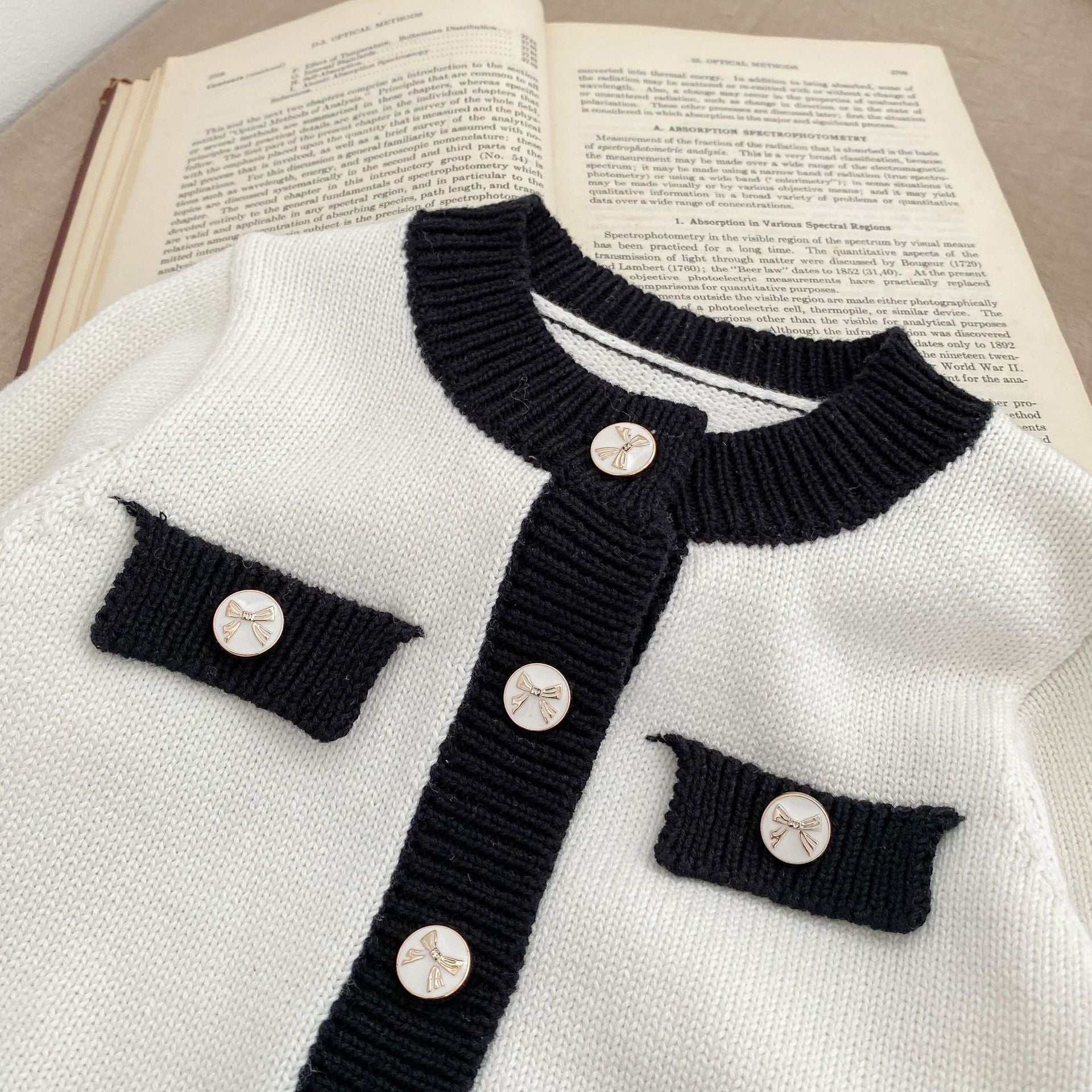 Baby girl wearing a stylish sleeveless onesie with a matching cardigan, showcasing a color matching design in soft cotton fabric.