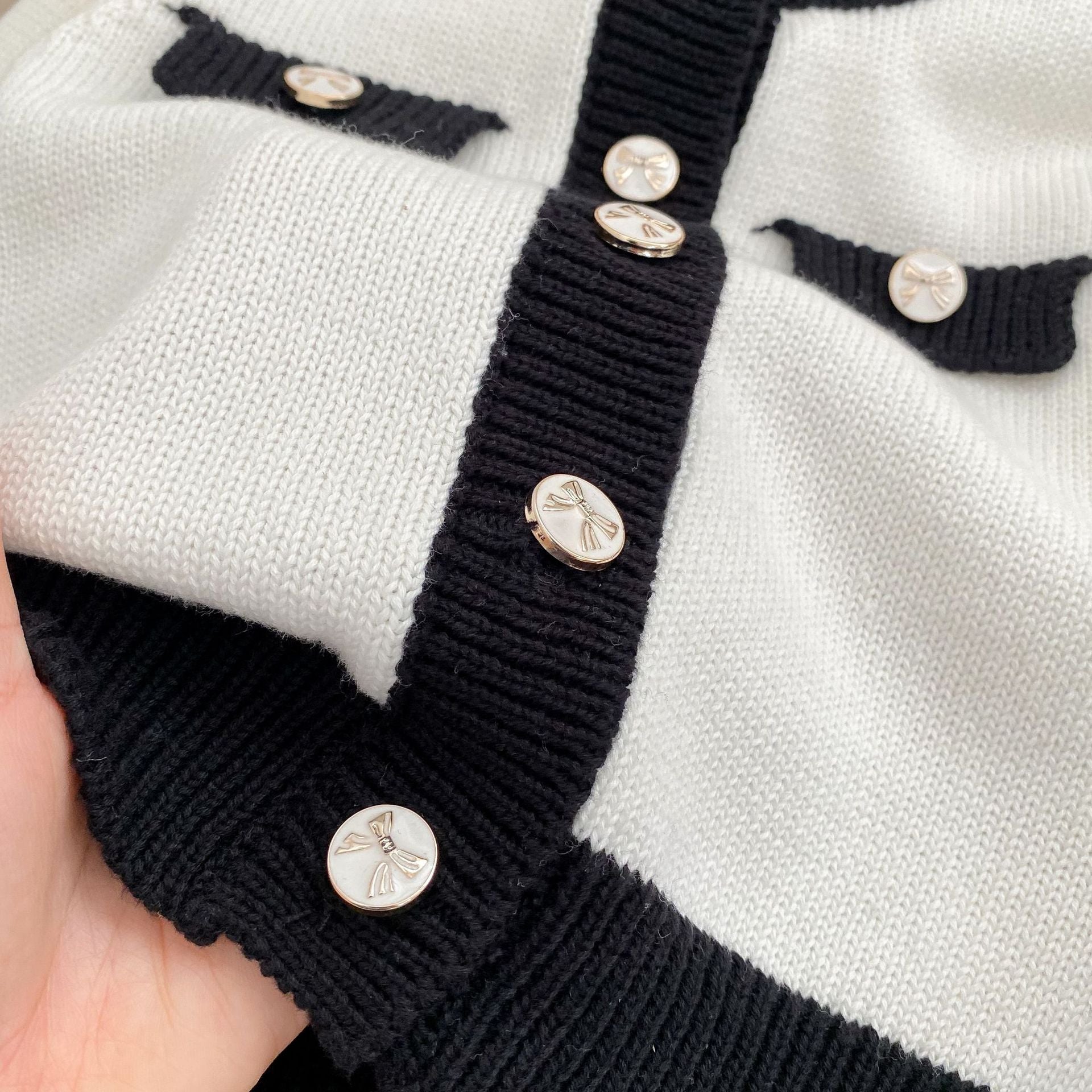 Baby girl wearing a stylish sleeveless onesie with a matching cardigan, showcasing a color matching design in soft cotton fabric.