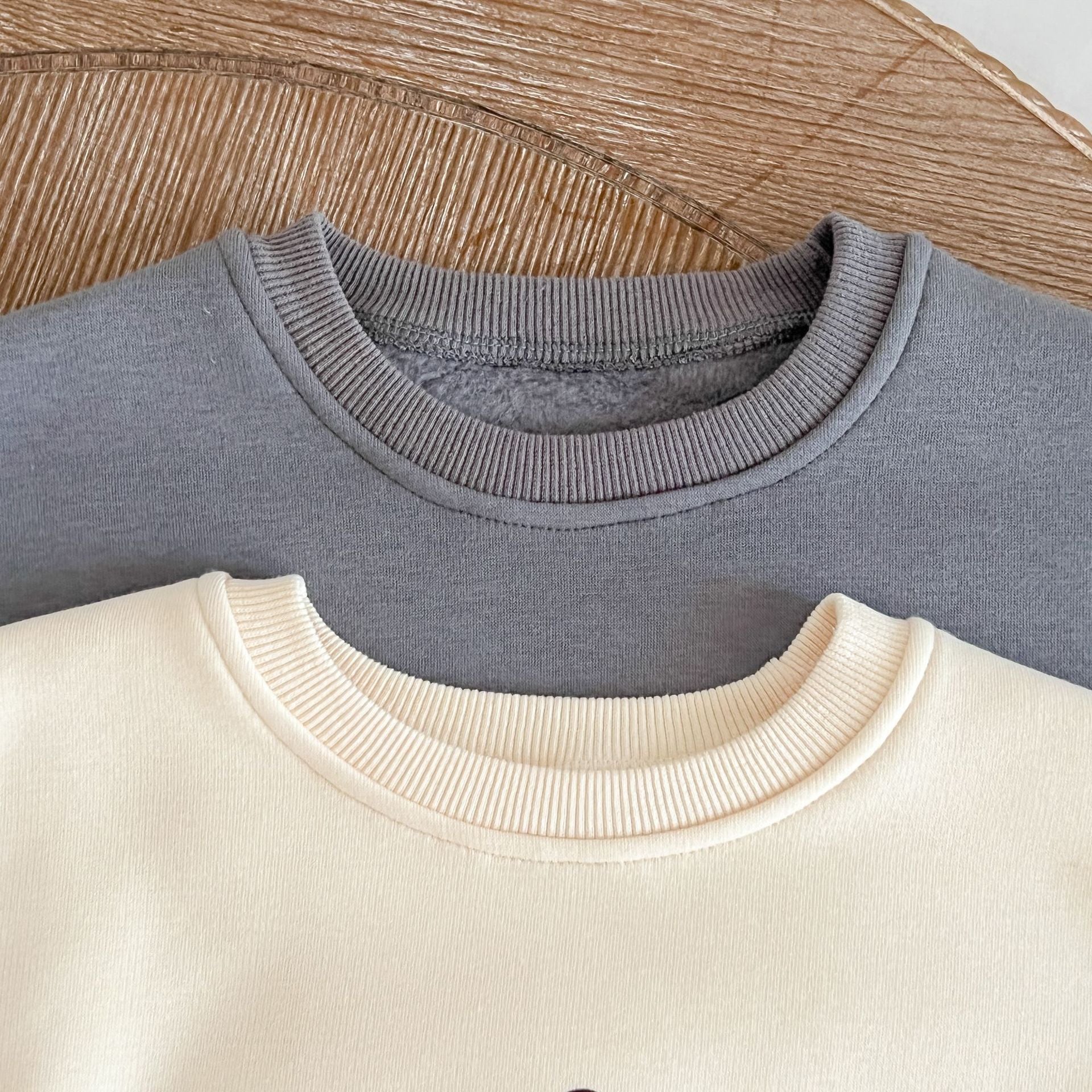 A cozy baby pullover onesie featuring a playful dinosaur print, perfect for autumn wear in apricot and brown colors.