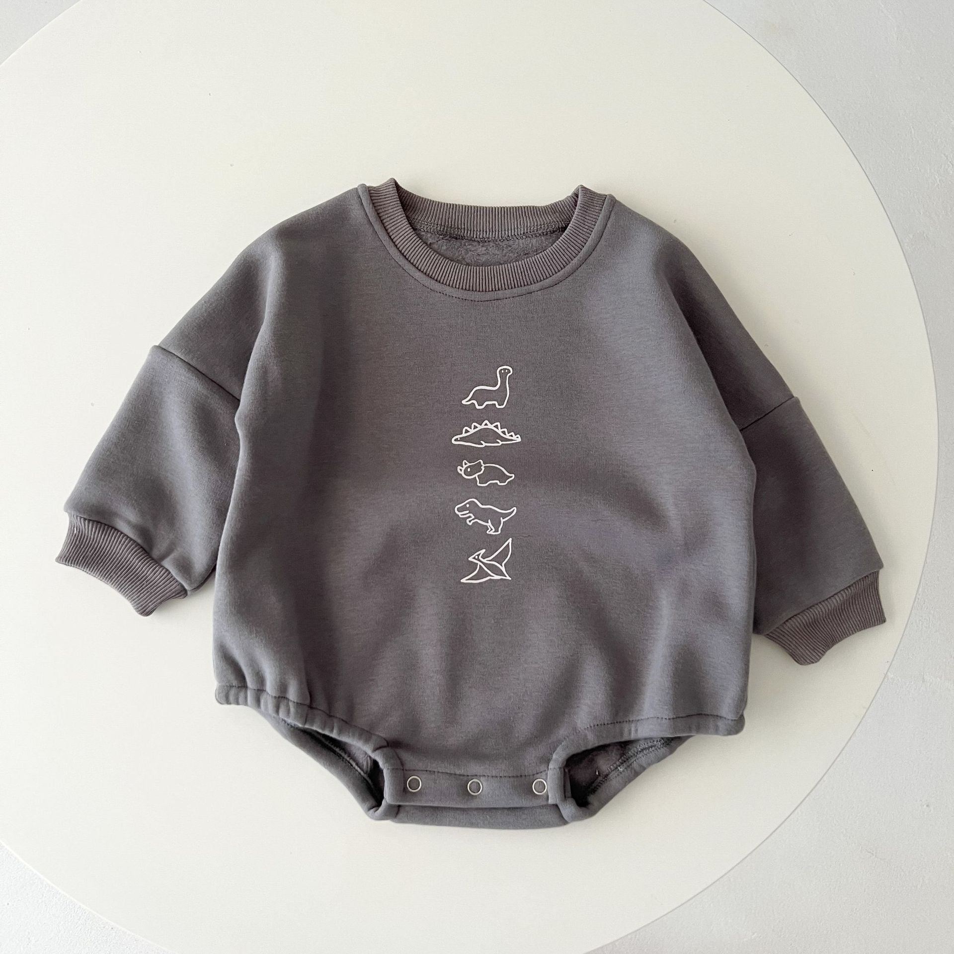 A cozy baby pullover onesie featuring a playful dinosaur print, perfect for autumn wear in apricot and brown colors.