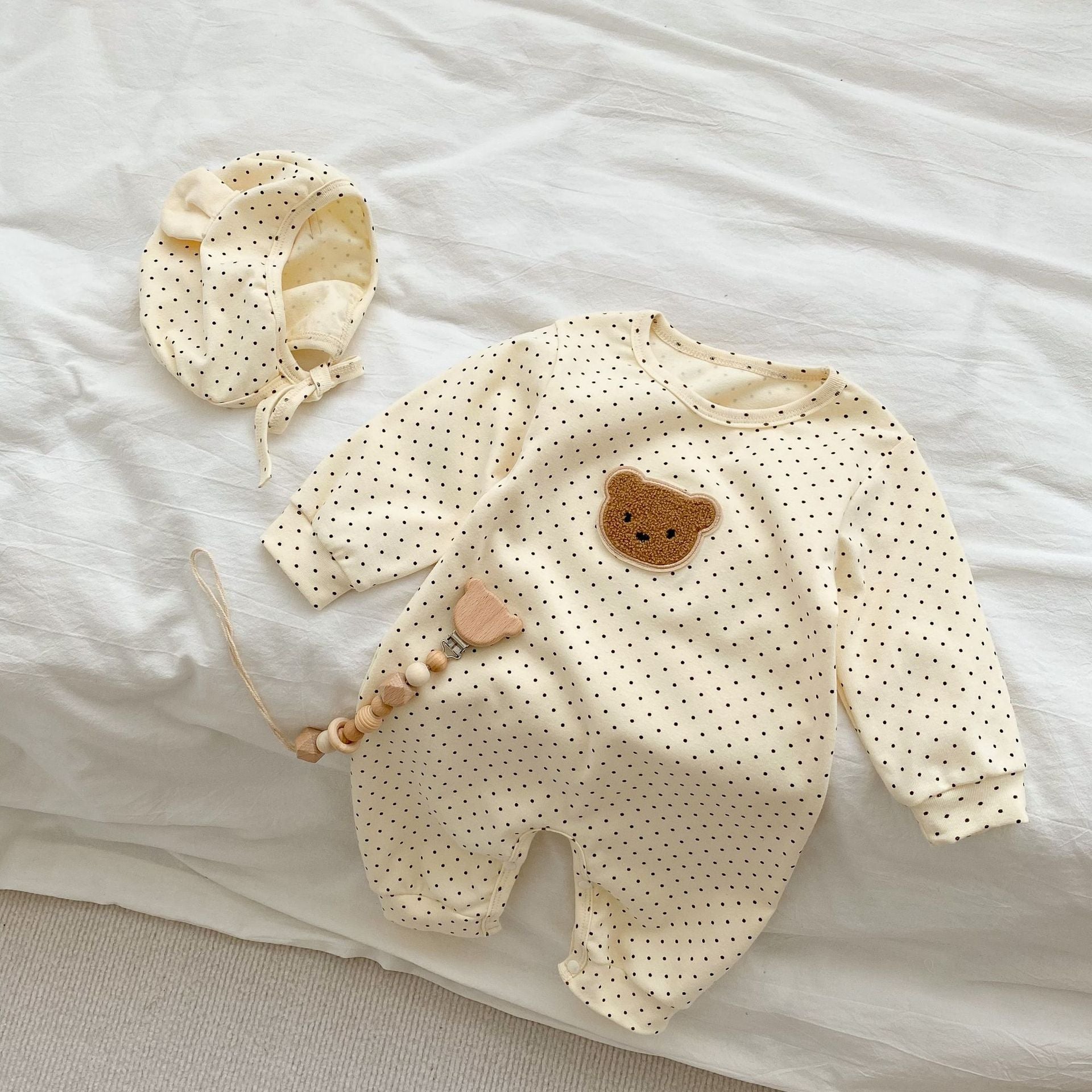 Baby jumpsuit featuring a cartoon bear design with a dot pattern, accompanied by a matching hat, perfect for infants.