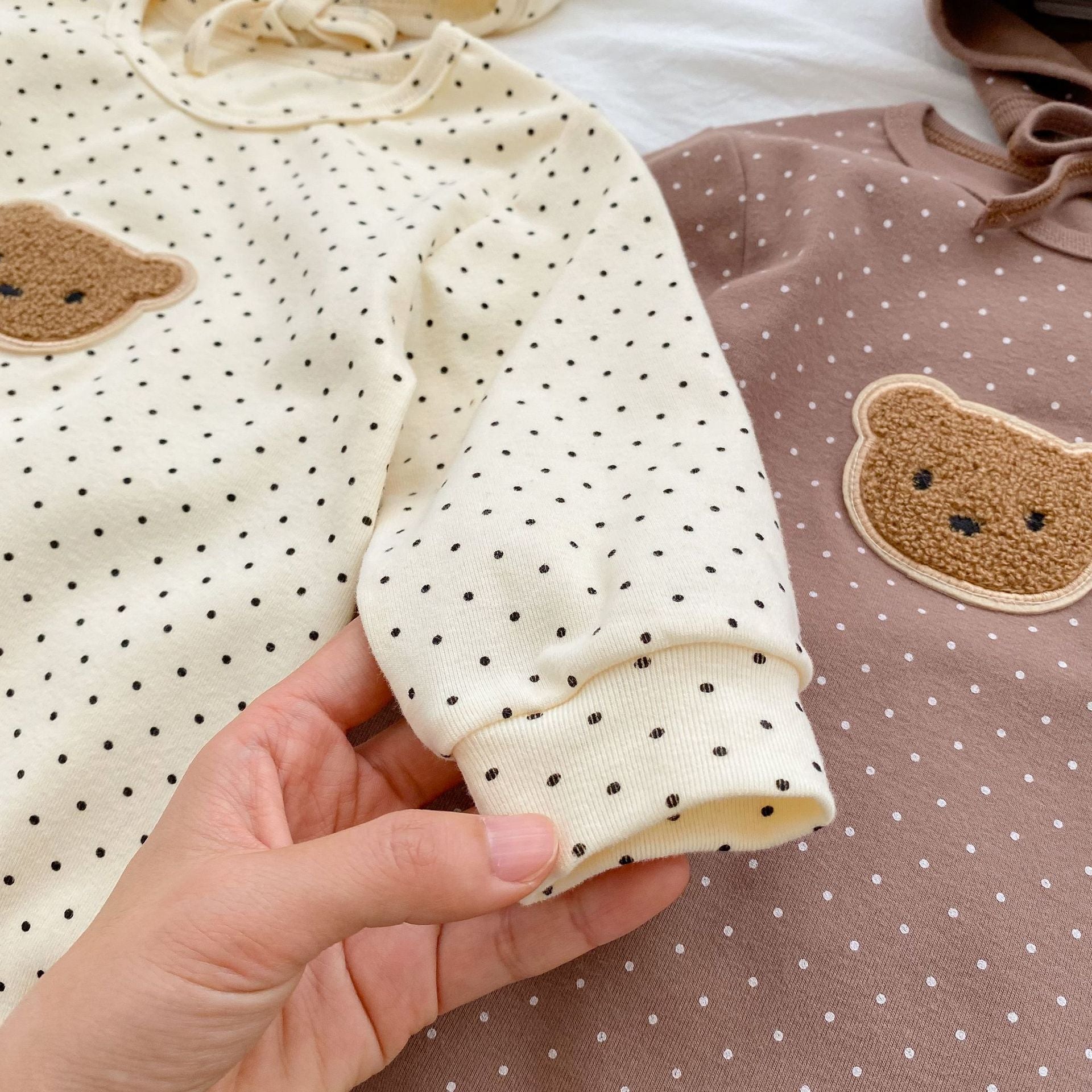 Baby jumpsuit featuring a cartoon bear design with a dot pattern, accompanied by a matching hat, perfect for infants.