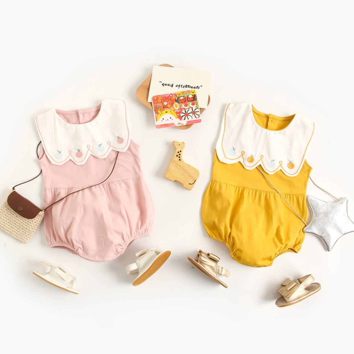 A collection of baby sleeveless onesies in pink and yellow with embroidered patterns, perfect for summer wear.