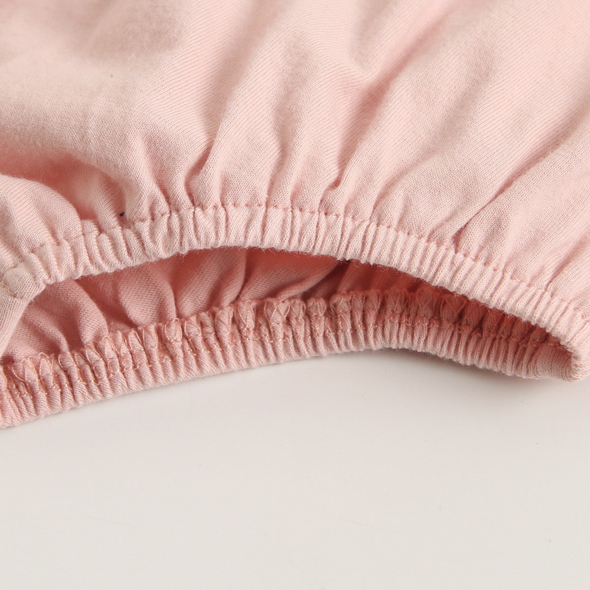 A collection of baby sleeveless onesies in pink and yellow with embroidered patterns, perfect for summer wear.