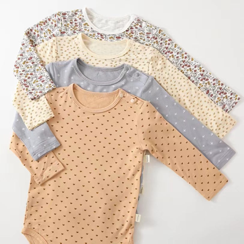 Soft cotton long sleeved onesies for babies featuring floral and heart patterns in white, pink, blue, and apricot colors.