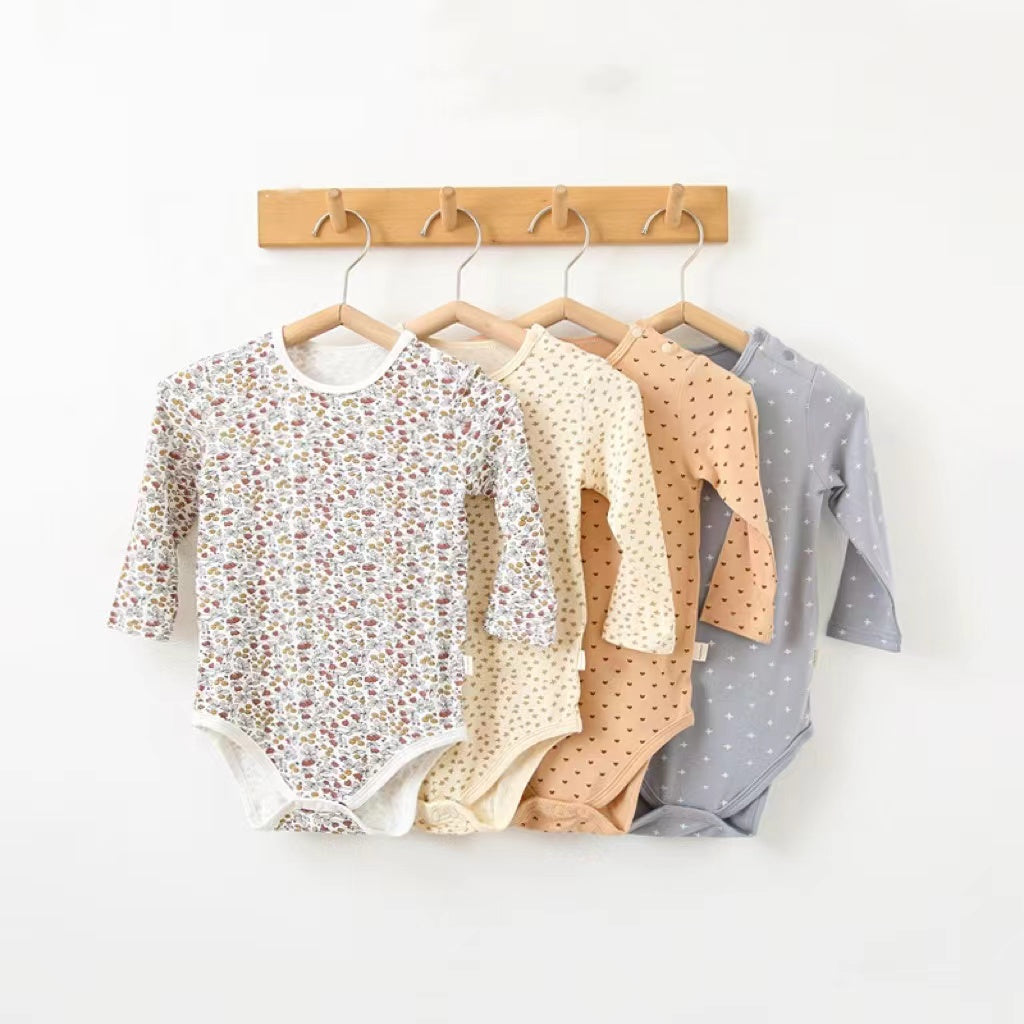 Soft cotton long sleeved onesies for babies featuring floral and heart patterns in white, pink, blue, and apricot colors.