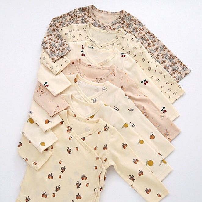 A cute baby outfit featuring a floral print pattern with a side buckle design, perfect for warm weather.