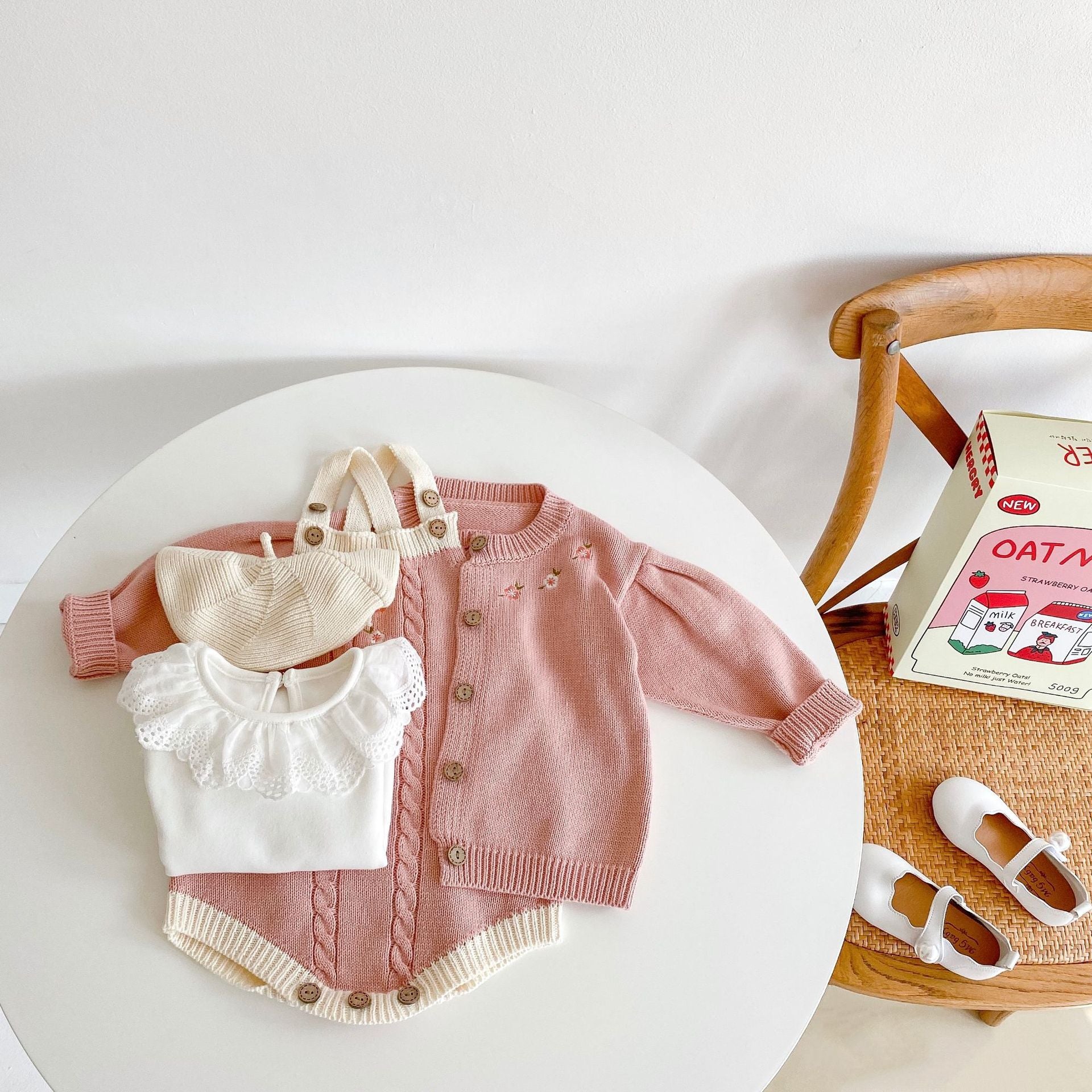 Baby girl wearing a crochet knitting onesie with floral cardigan, showcasing a graphic contrast design in pink and apricot colors.