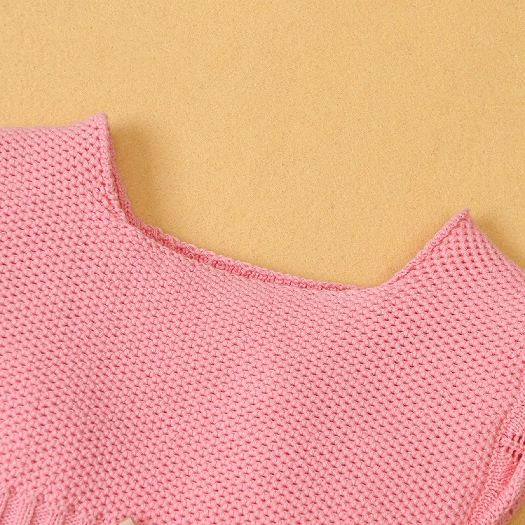 Baby girl wearing a ribbed knitted onesie with ruffle design in pink color, showcasing a stylish and comfortable outfit.