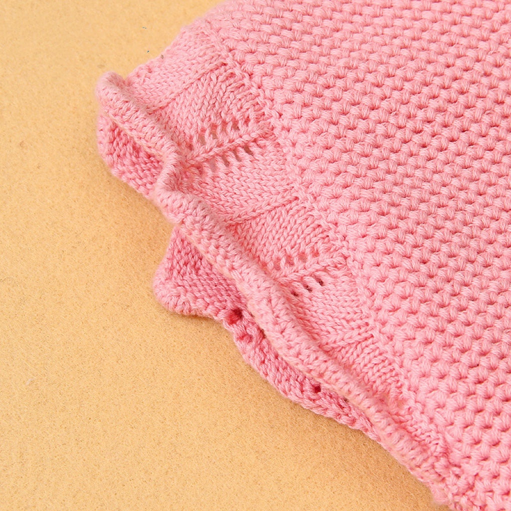 Baby girl wearing a ribbed knitted onesie with ruffle design in pink color, showcasing a stylish and comfortable outfit.