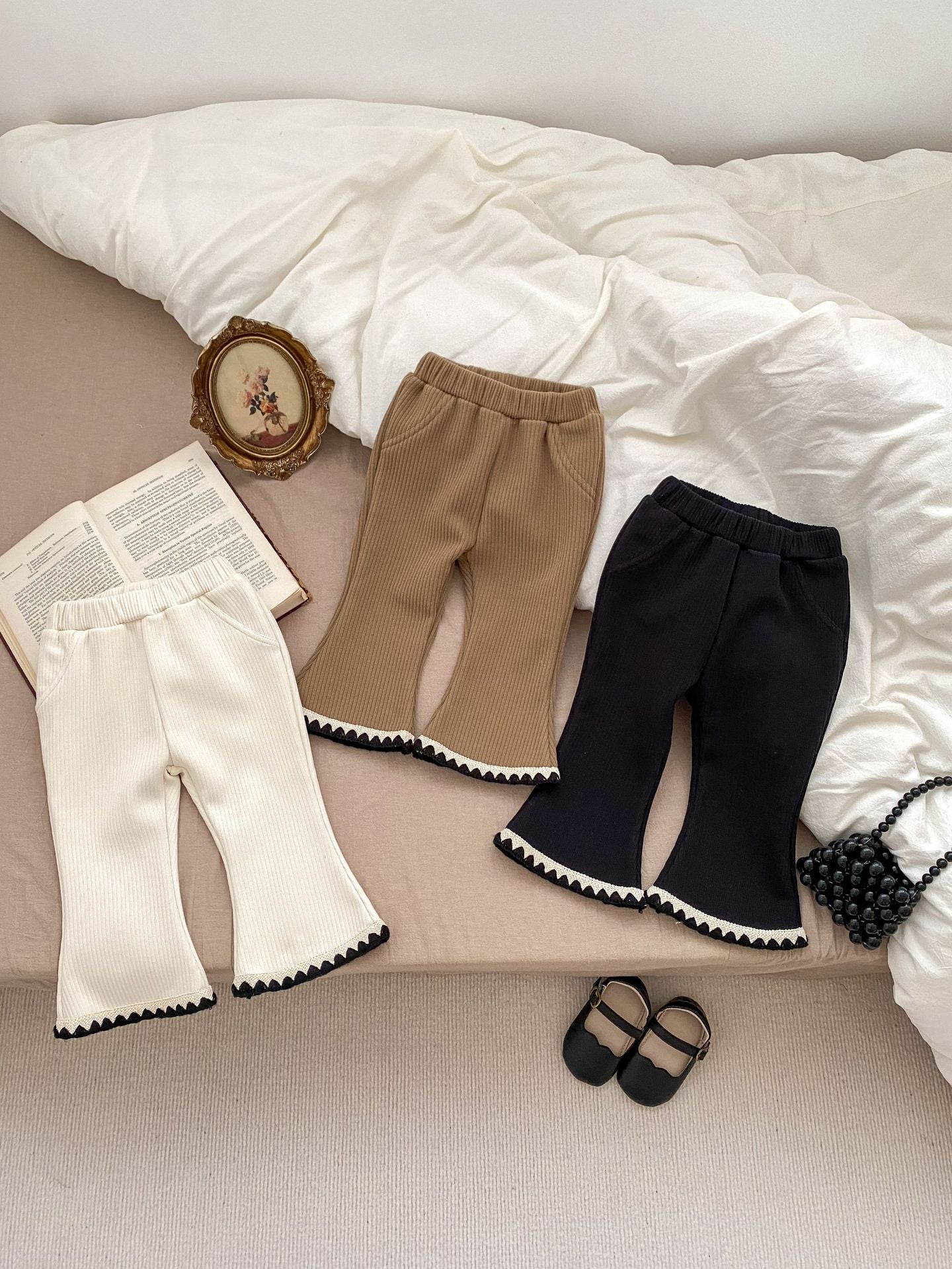 Baby girl flared pants in black, beige, and brown colors, made of soft cotton, perfect for winter wear.