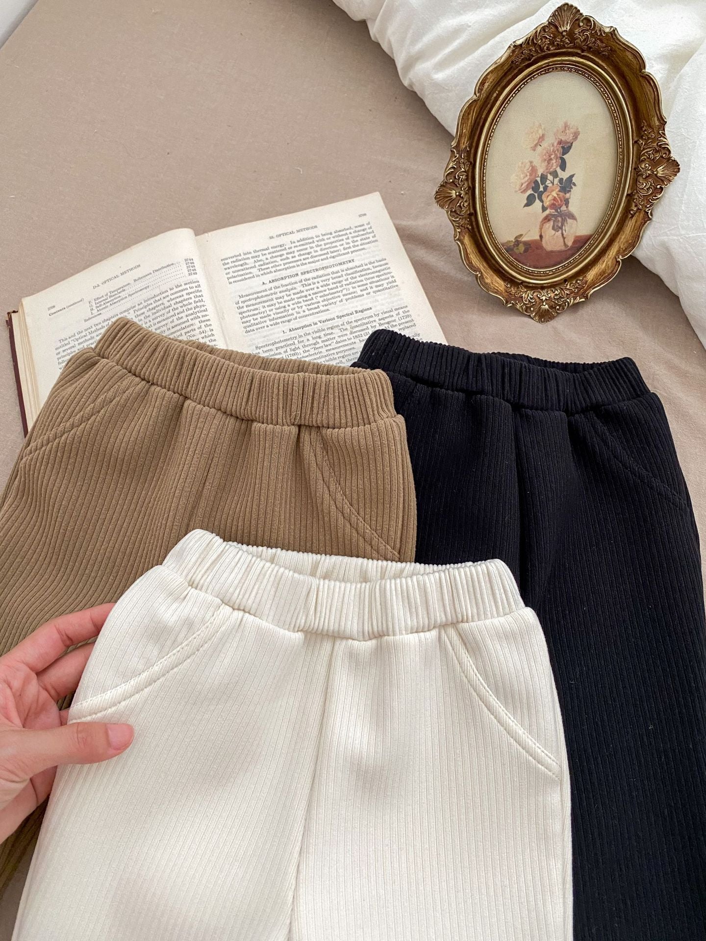 Baby girl flared pants in black, beige, and brown colors, made of soft cotton, perfect for winter wear.