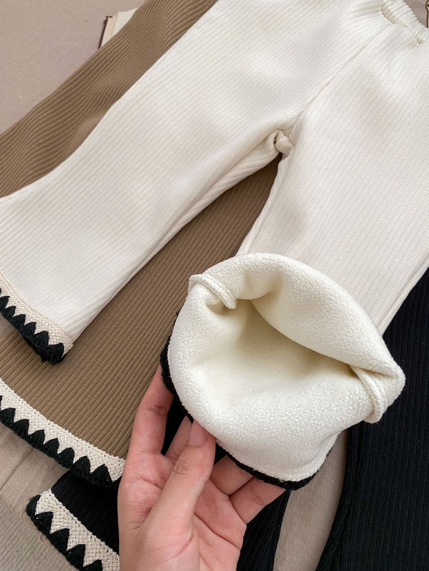 Baby girl flared pants in black, beige, and brown colors, made of soft cotton, perfect for winter wear.