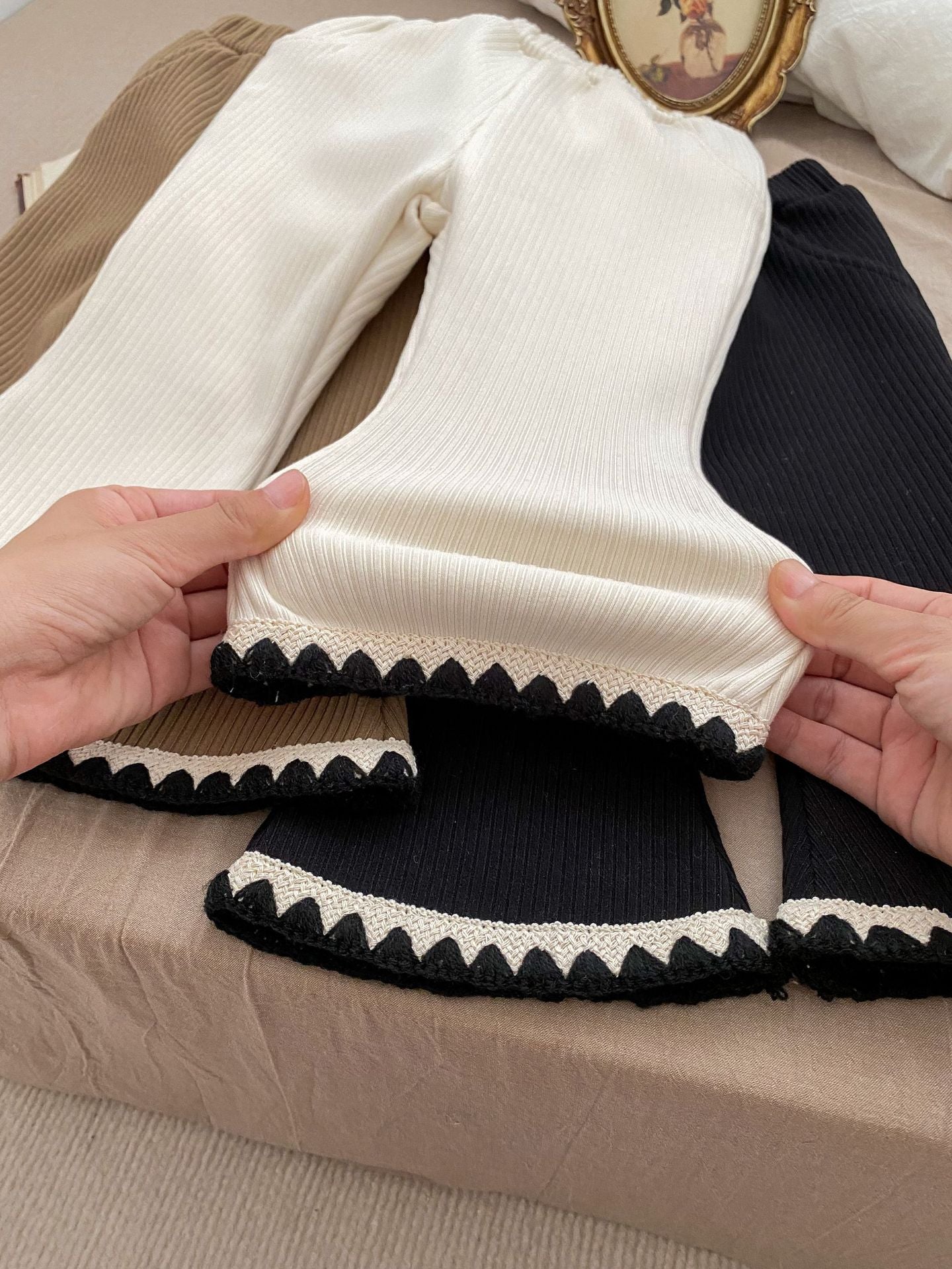 Baby girl flared pants in black, beige, and brown colors, made of soft cotton, perfect for winter wear.