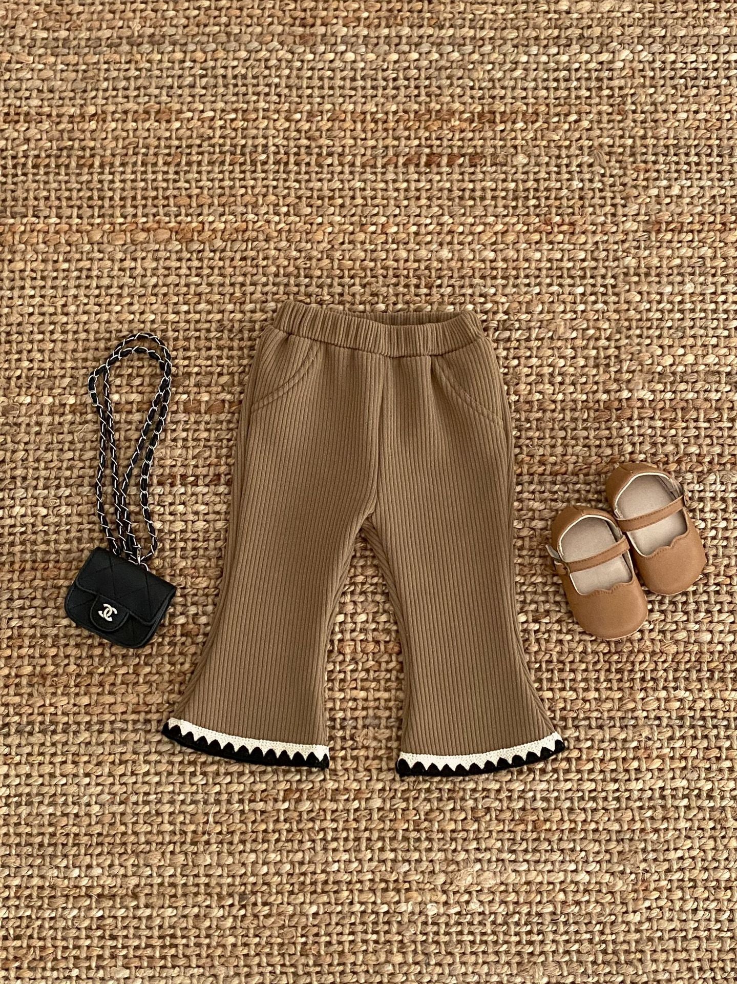 Baby girl flared pants in black, beige, and brown colors, made of soft cotton, perfect for winter wear.