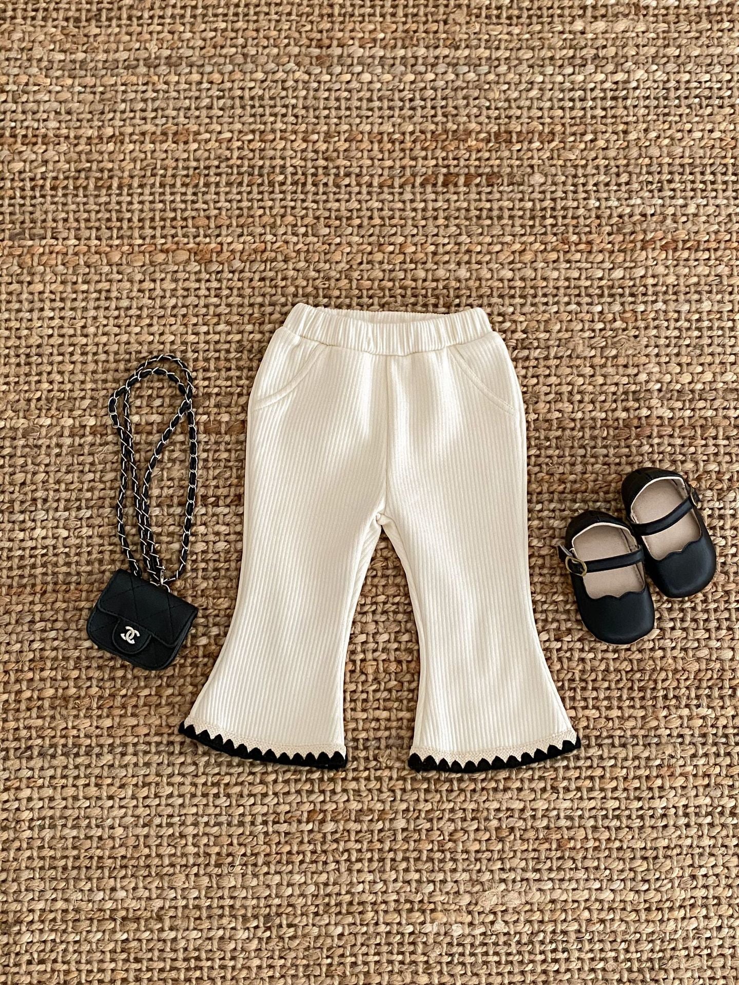 Baby girl flared pants in black, beige, and brown colors, made of soft cotton, perfect for winter wear.