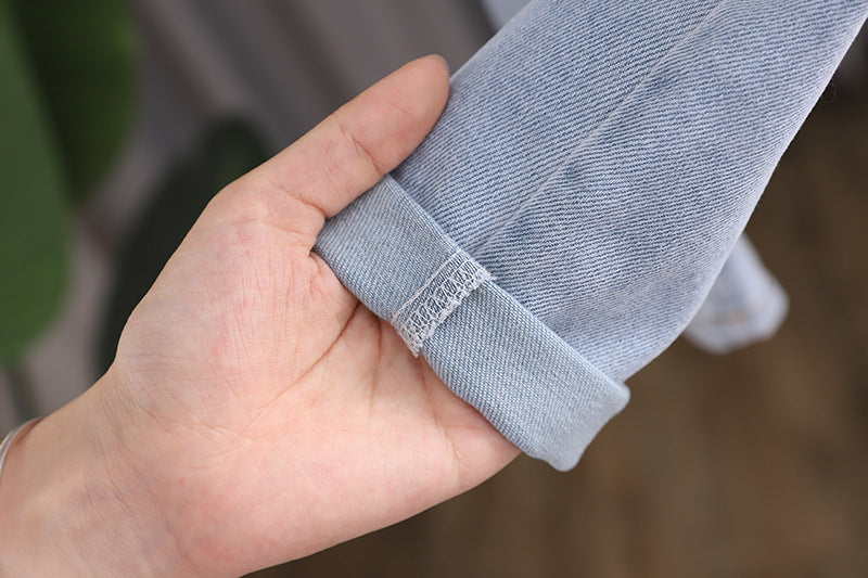 Baby girl wearing a stylish denim overall with 3D wing patches, showcasing a playful and fashionable design.