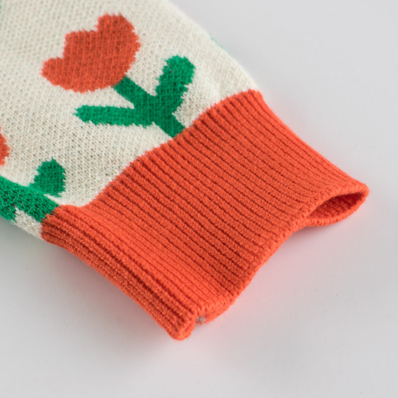A cozy baby girl knitted cardigan featuring a vibrant floral pattern in orange, perfect for autumn outfits.