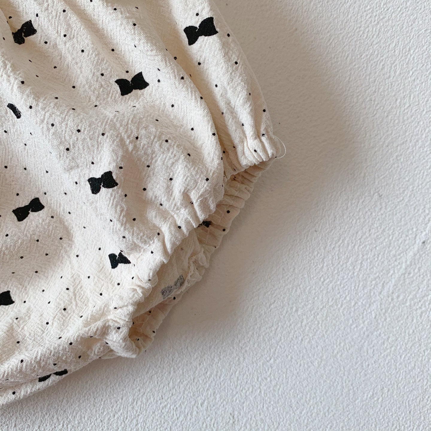 Baby girl wearing a stylish bow and polka dot A-line long sleeves shirt combo in apricot color.