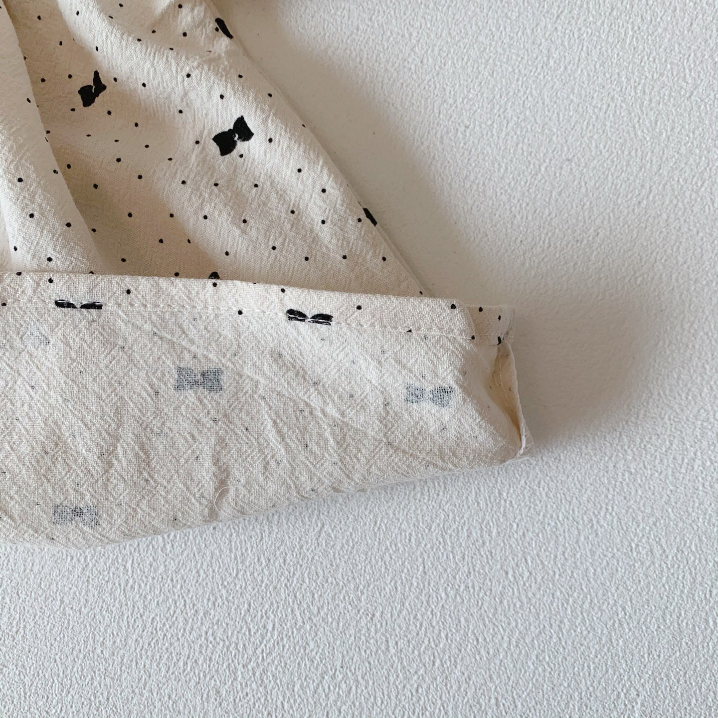 Baby girl wearing a stylish bow and polka dot A-line long sleeves shirt combo in apricot color.