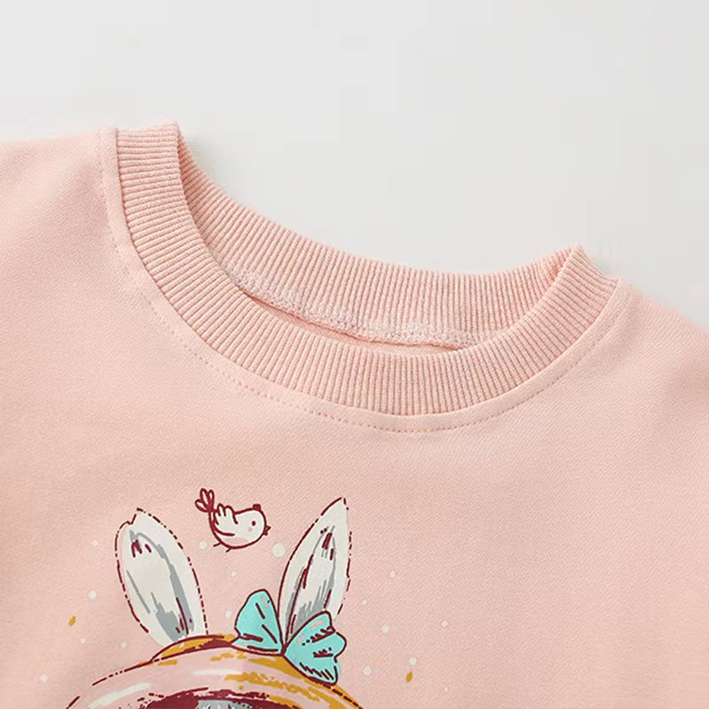 Baby girl wearing a pink cartoon print pullover hoodie with a round neck, featuring playful animal designs.