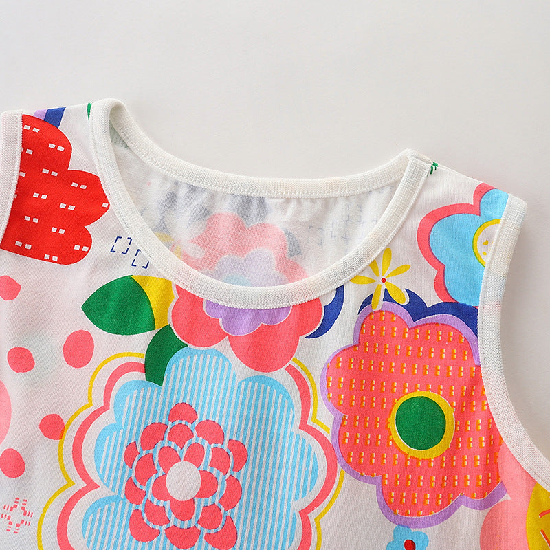 A cute baby girl wearing a sleeveless cartoon print summer dress in white, featuring colorful floral and rainbow patterns.