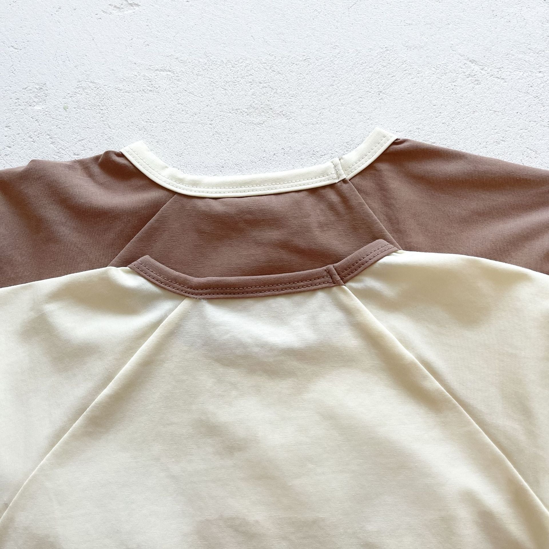 Baby girl wearing a cute smile face print onesie, showcasing a soft cotton blend fabric and short sleeves.