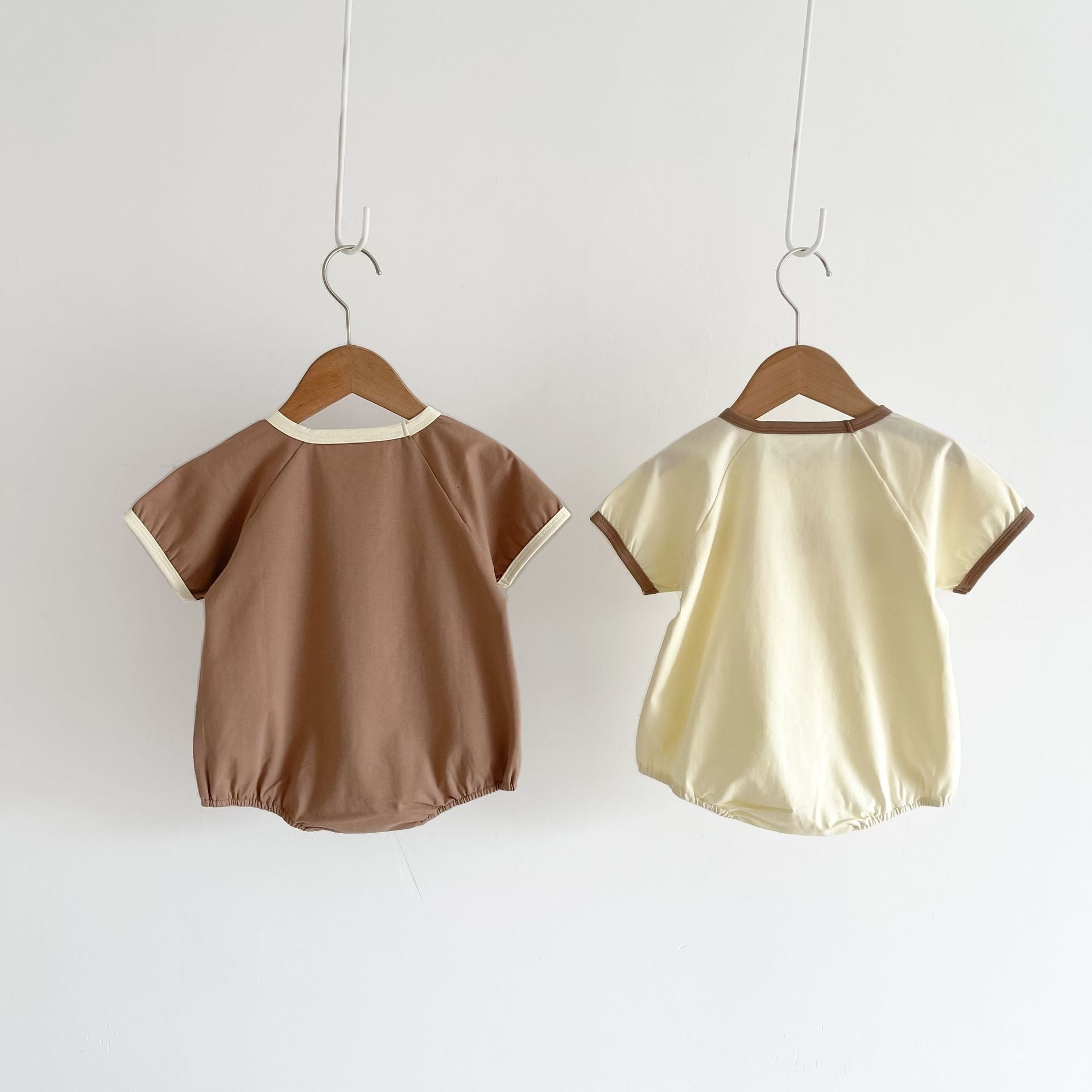 Baby girl wearing a cute smile face print onesie, showcasing a soft cotton blend fabric and short sleeves.