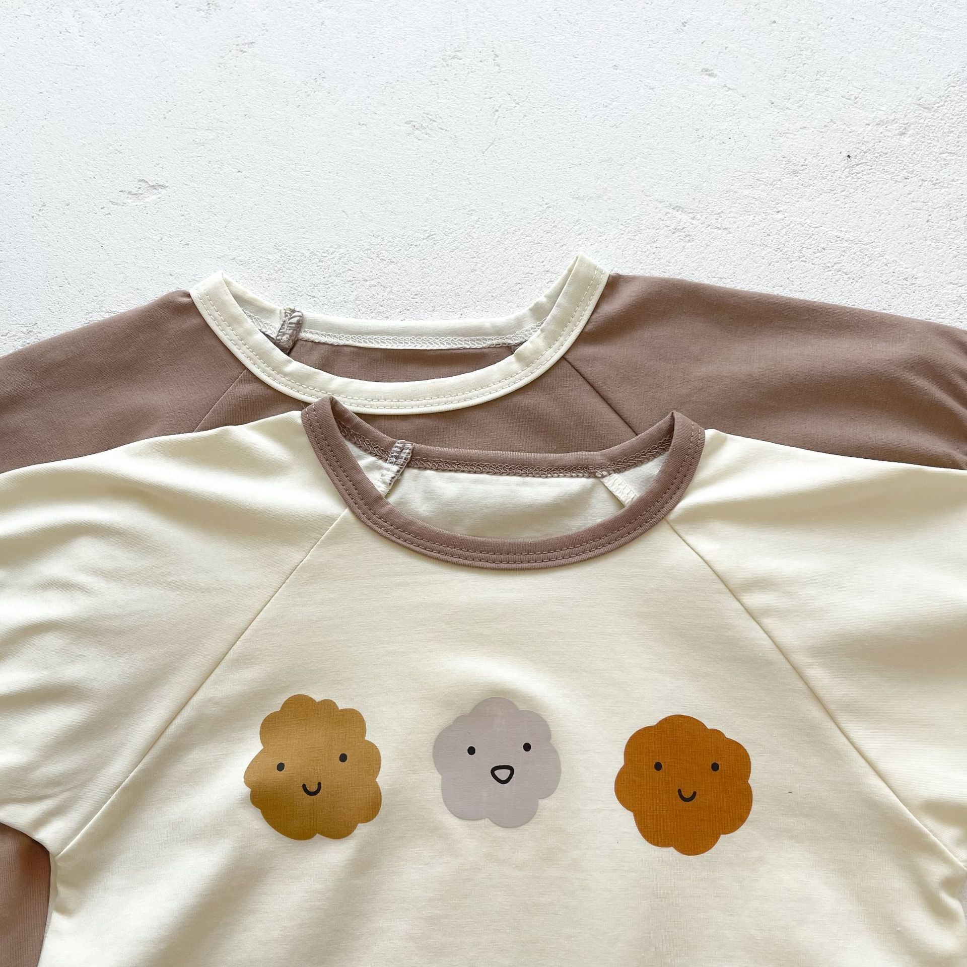 Baby girl wearing a cute smile face print onesie, showcasing a soft cotton blend fabric and short sleeves.