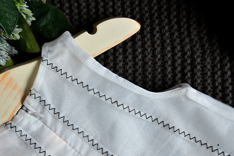 A charming white sleeveless dress for baby girls featuring dimensional butterfly embroidery and lace patchwork, perfect for summer occasions.