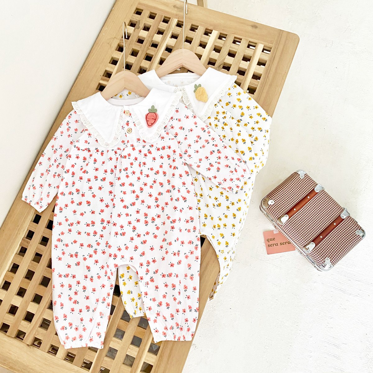 Baby girl romper featuring a ditsy floral print and embroidered carrot pattern, available in pink and yellow colors.