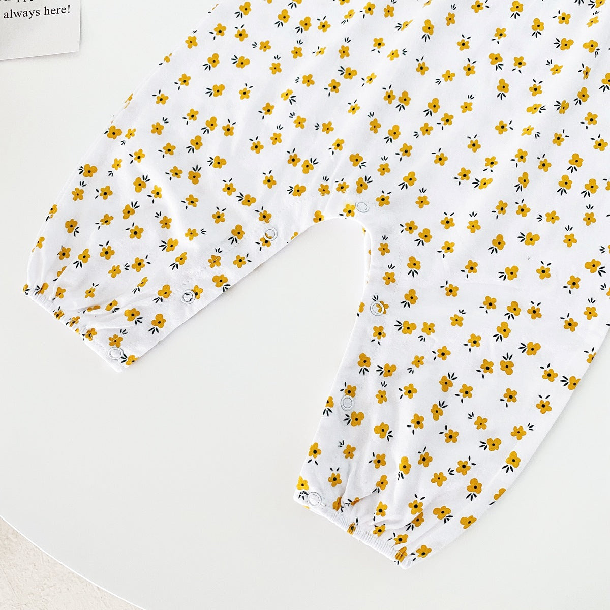 Baby girl romper featuring a ditsy floral print and embroidered carrot pattern, available in pink and yellow colors.