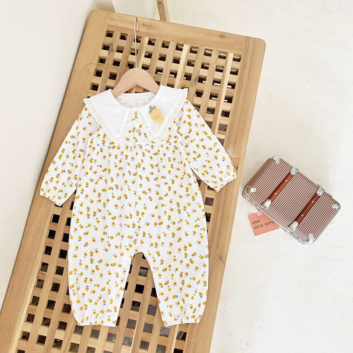 Baby girl romper featuring a ditsy floral print and embroidered carrot pattern, available in pink and yellow colors.