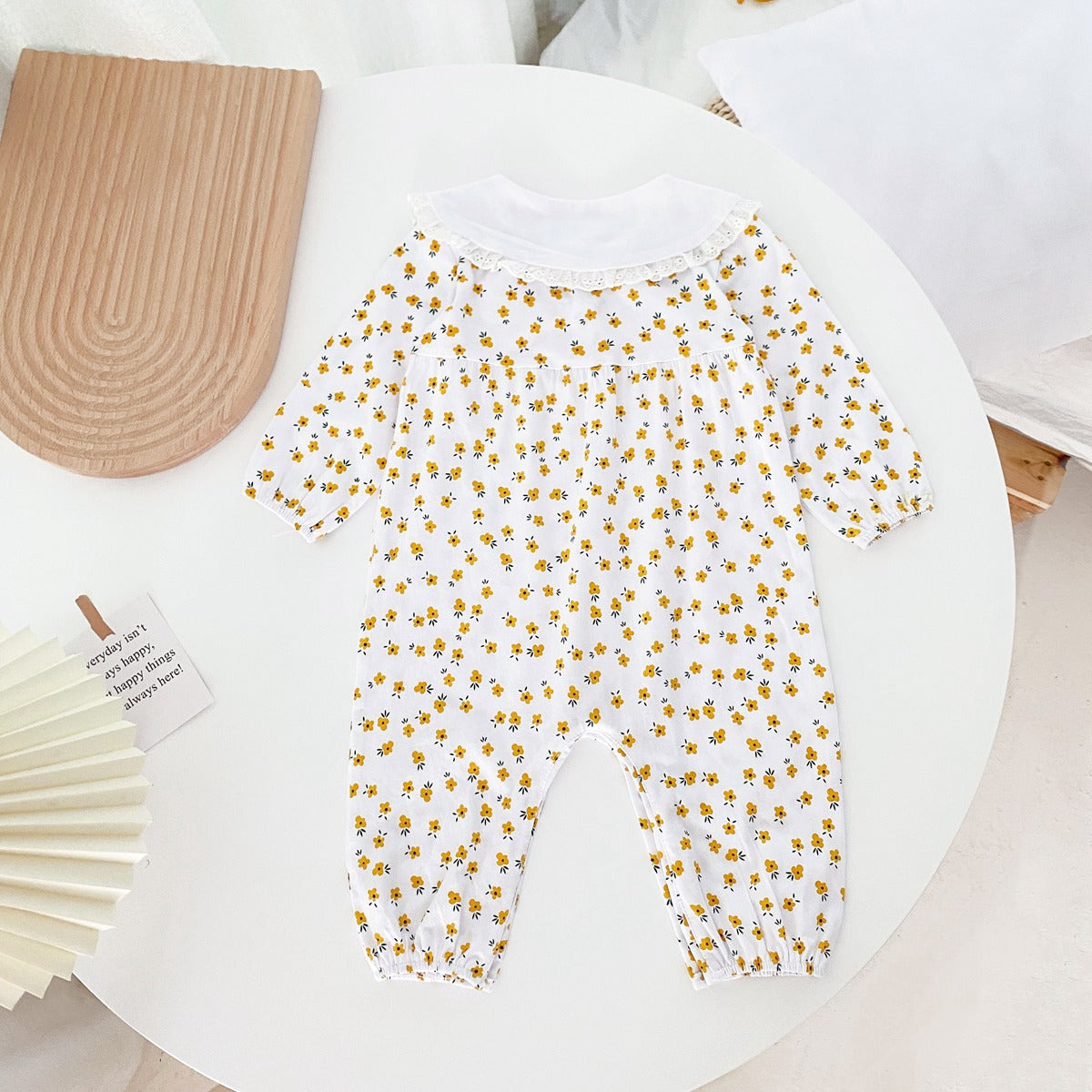 Baby girl romper featuring a ditsy floral print and embroidered carrot pattern, available in pink and yellow colors.