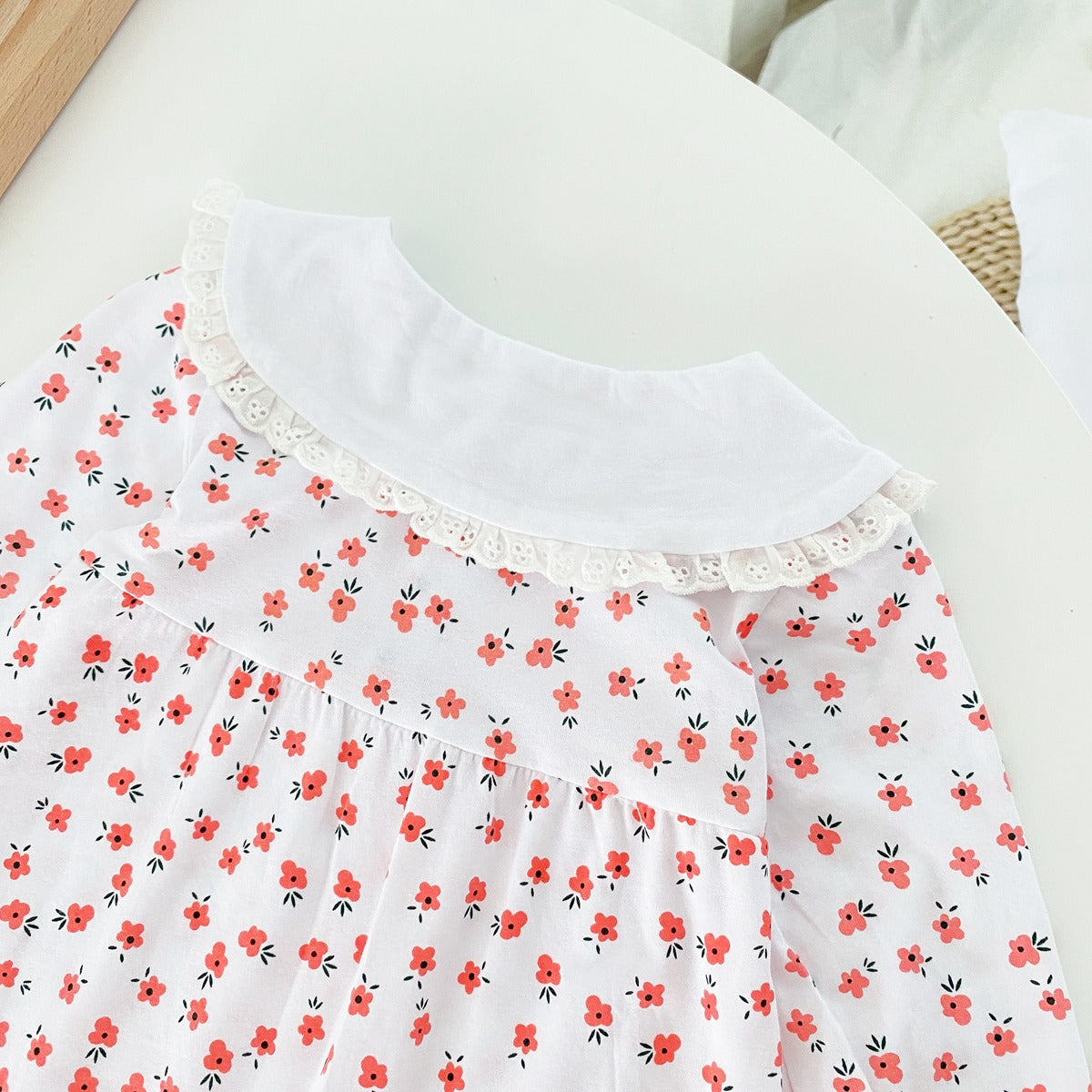 Baby girl romper featuring a ditsy floral print and embroidered carrot pattern, available in pink and yellow colors.