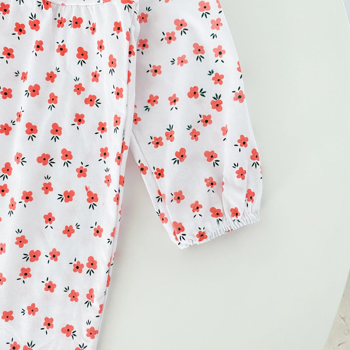 Baby girl romper featuring a ditsy floral print and embroidered carrot pattern, available in pink and yellow colors.