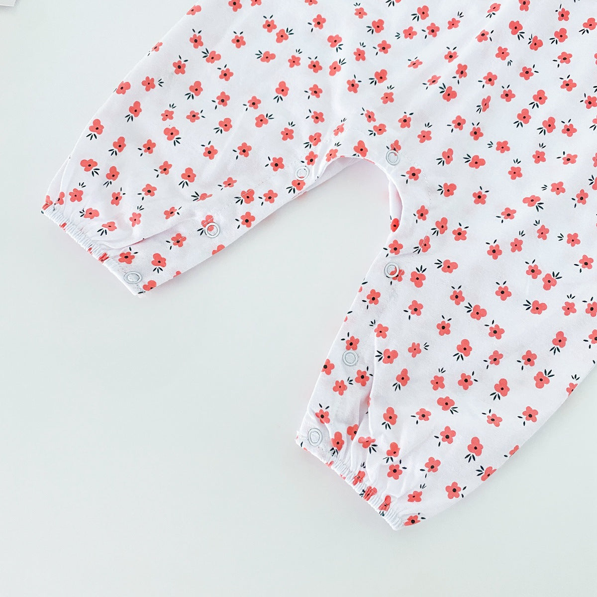 Baby girl romper featuring a ditsy floral print and embroidered carrot pattern, available in pink and yellow colors.