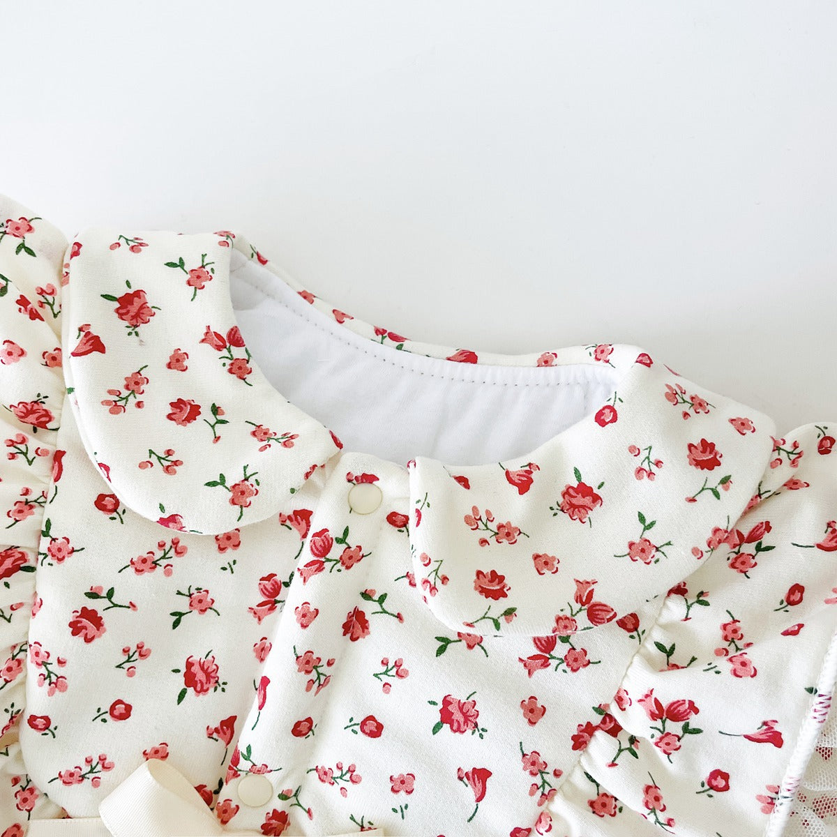 Baby girl romper featuring a ditsy flower pattern and mesh patches, designed for comfort and style.